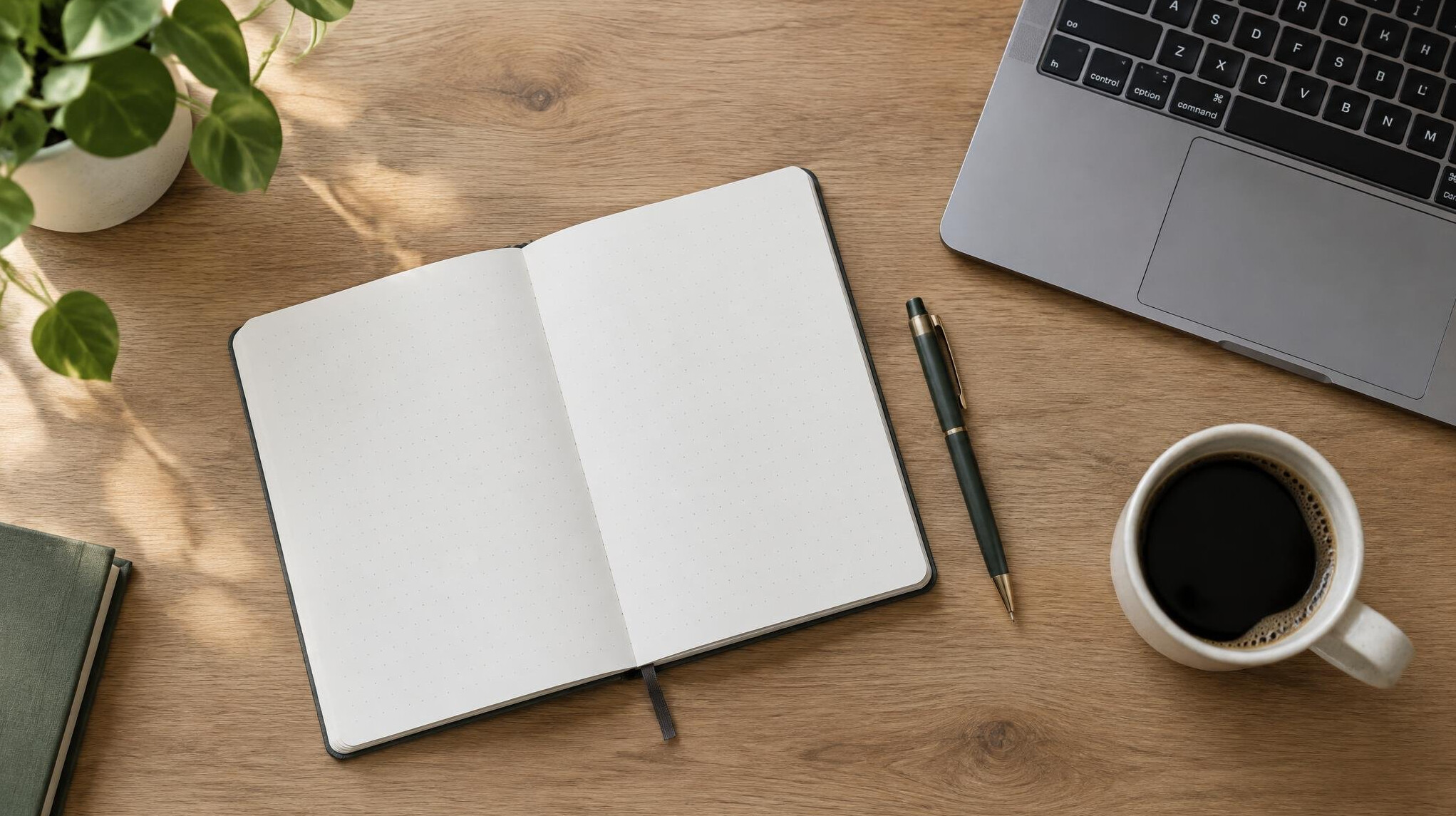 Vista superior de um caderno, caneta e laptop em uma mesa de madeira